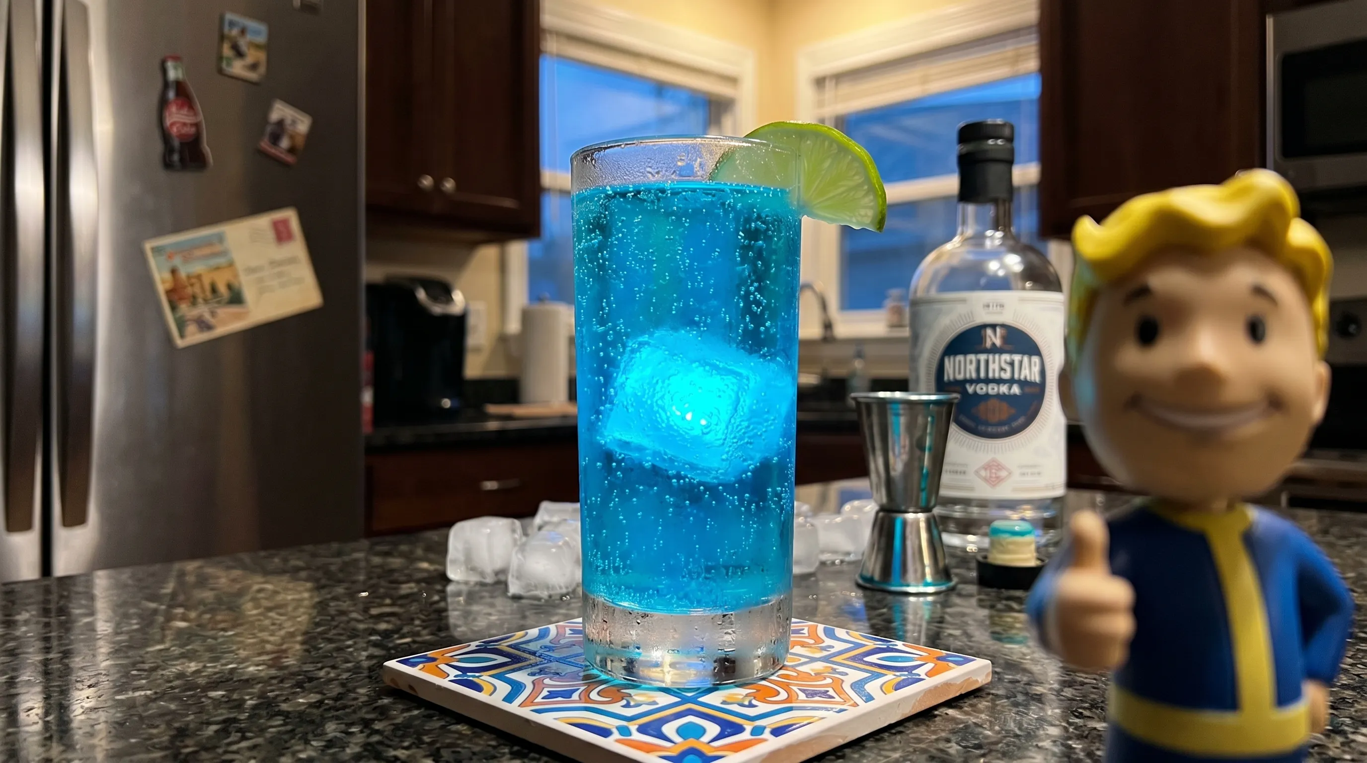 My Wasteland Glow — electric blue Nuka-Cola Quantum on a patterned tile trivet, Vault Boy bobblehead at the edge